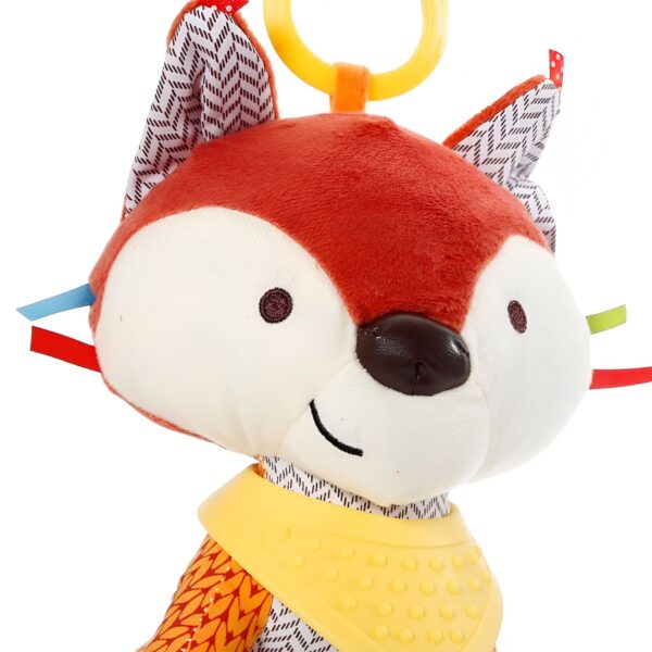 Un renard en peluche souriant avec un bavoir jaune et un anneau de dentition jaune.