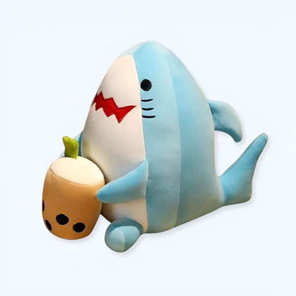 Une peluche de requin bleu souriant tenant un boba tea.