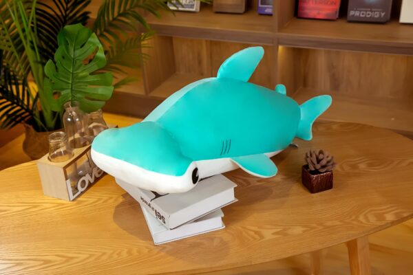 Une peluche de requin marteau bleu sur une table en bois.