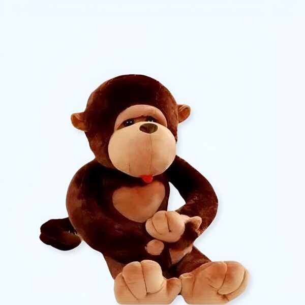 Une peluche de singe brun assis sur le sol avec sa langue tirée.