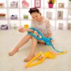 peluche-singe-kawaii-jaune-a-longue-queue-jouet-doux-pour-enfant-2a-2 Une jeune femme joue avec deux singes en peluche, un bleu et un jaune. Les singes ont de longs bras.