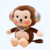 Un singe en peluche brun portant un bandeau arc-en-ciel sur les oreilles et un foulard musical.