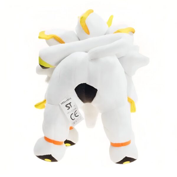 Peluche blanche représentant le Pokémon légendaire Arceus, vu de dos. Il a une queue jaune et des détails noirs sur son corps. Il est prêt à être câliné !