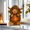peluche-taureau-respirant-lumineux-35cm-berceuse-apaisante-2a-2 Une peluche en forme de yack brun avec des lumières LED dans son ventre, assise sur un comptoir de cuisine.