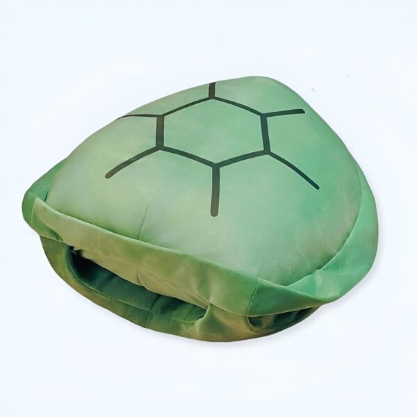 Un coussin en forme de tortue verte avec une carapace noire.