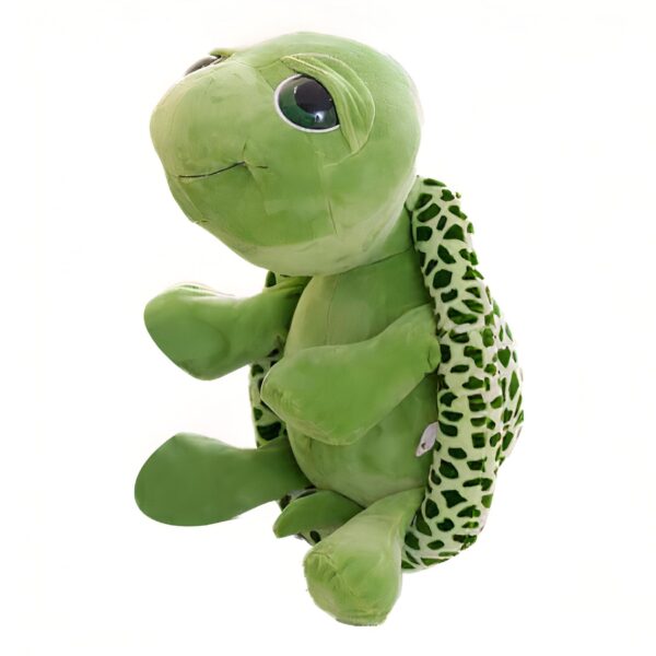 Une peluche verte de tortue avec de grands yeux noirs. La tortue a une carapace verte et blanche.