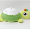 Une tortue en peluche verte avec une projection d'étoiles sur le dos. La tortue a un visage souriant avec un œil noir et une petite bouche.