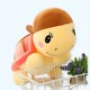 Une peluche de tortue jaune avec une coquille rose et des cils. La tortue est dans un panier en métal.