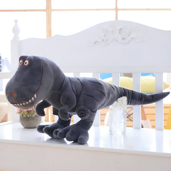 Une peluche de dinosaure gris assis sur un banc blanc.