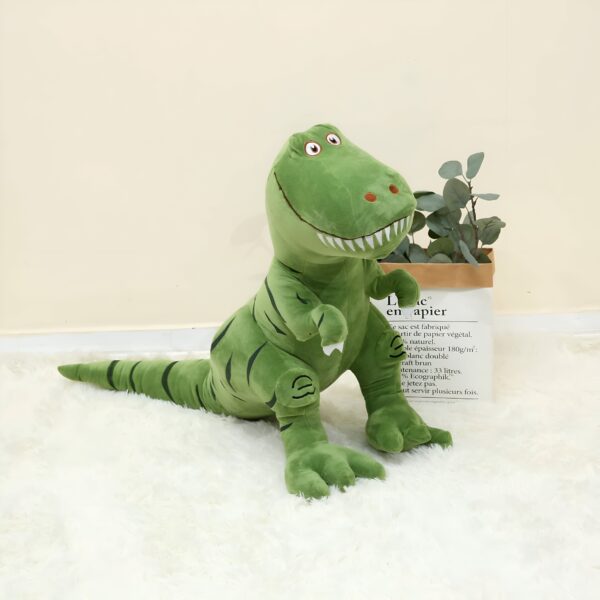 Une peluche de dinosaure vert avec des yeux noirs et une bouche ouverte.