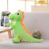 Gros dinosaure vert en peluche avec des détails orange sur un canapé gris.