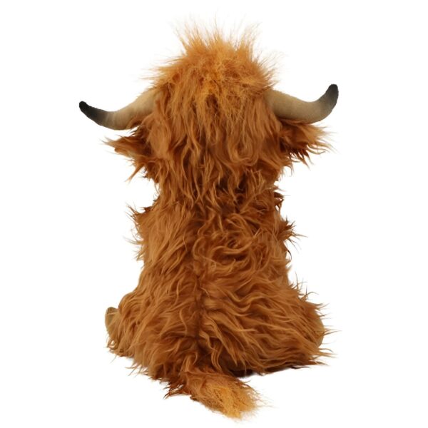 Une peluche de vache écossaise assise de dos avec une fourrure brune et des cornes.