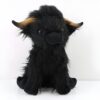Une peluche noire et moelleuse en forme de vache Highland avec des cornes courtes et brunes.