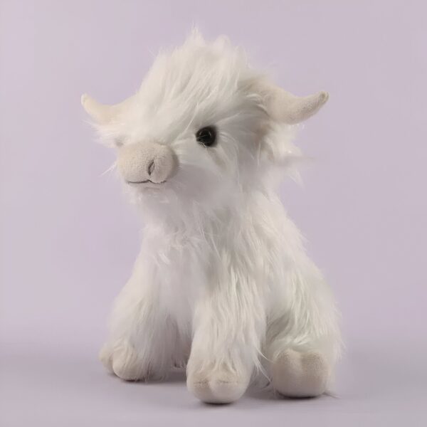 Une peluche blanche de vache Highland, assise sur un fond violet.