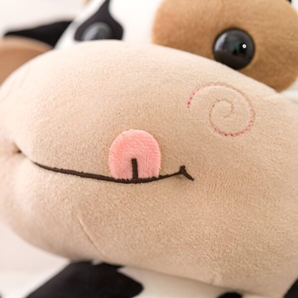 Gros plan sur la bouche d'une peluche vache avec une langue rose.