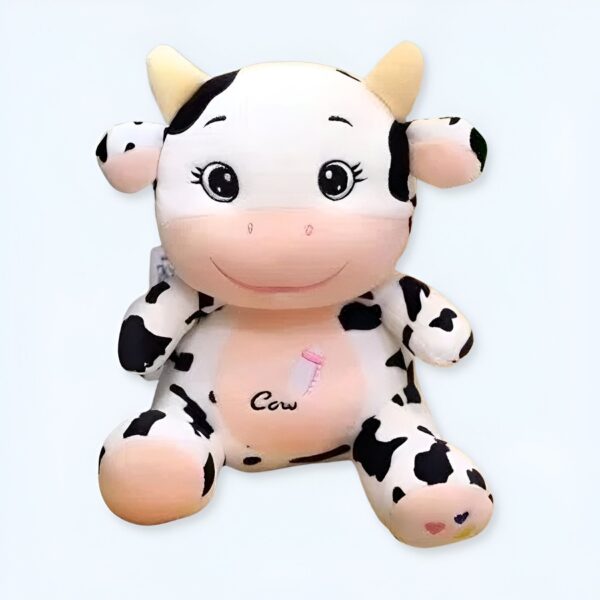 Peluche vache en position assise avec des taches noires et blanches, souriant avec un biberon brodé sur la poitrine.