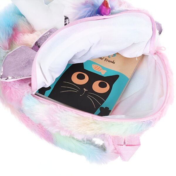 Sac à dos licorne en fourrure arc-en-ciel ouvert, montrant un livre avec un chat noir à l'intérieur.