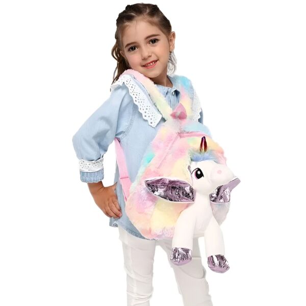 Une jeune fille souriante porte un sac à dos en forme de licorne arc-en-ciel.